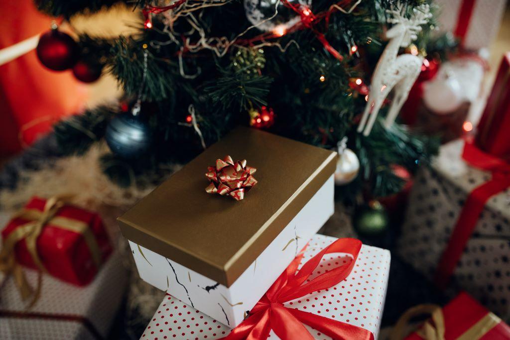 Des cadeaux de Noël emballés sous un sapin